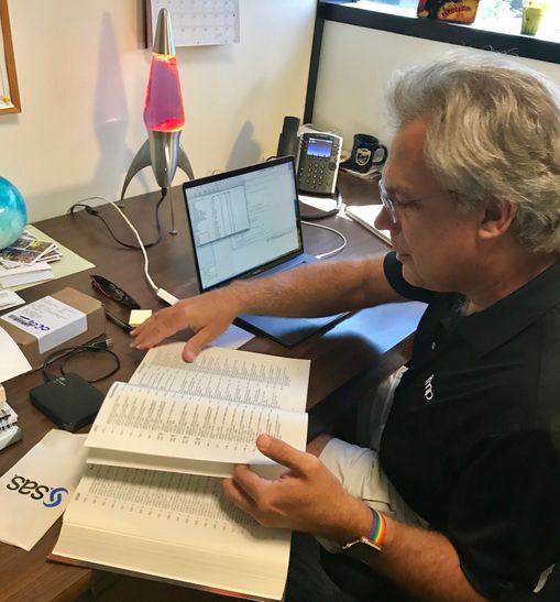 JMP developer Michael Hecht pages through The Unicode Standard 4.0 in his office. JMP recently adopted a Unicode character, the lightbulb emoji.